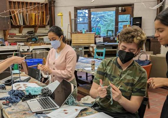 Students work on tapestries representing sulfur dioxide emissions from coal-fired power plants